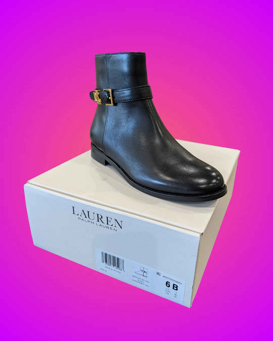 Lauren Ralph Lauren Brooke ankle boot in smooth black leather with a gold-toned buckle strap and a low heel, sitting on its cream Lauren box